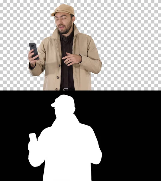 Ung man ringer ett videosamtal från sin mobiltelefon när han går, Alpha Channel — Stockfoto