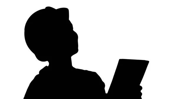 Silhouette Female construction engineer with a tablet computer at a construction site. — Stock Photo, Image