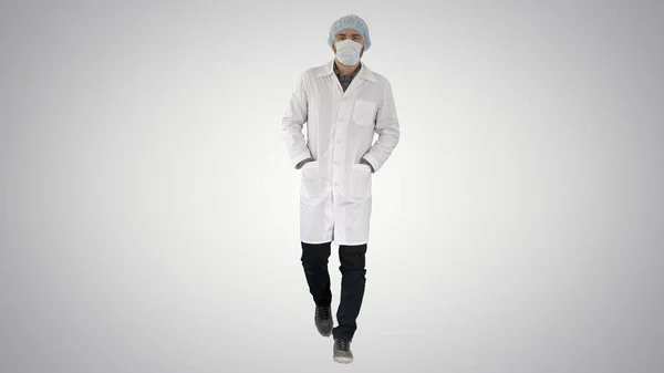 Caminante joven médico masculino con máscara quirúrgica sobre fondo de gradiente . — Foto de Stock