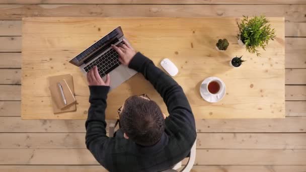 Homme occasionnel travaillant sur un ordinateur portable dans un bureau décontracté . — Video