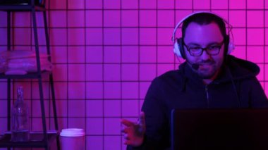 Neşeli genç oyuncu evde çalışan bir bilgisayar akışında video oyunları oynuyor.