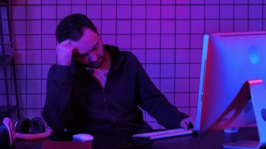 Bilgisayar işleme sırasında bilgisayar başında uyuyan yorgun hacker.