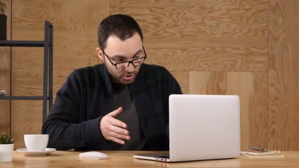 Gelukkig bebaarde hipster man hand zwaaien en praten over video-chat met behulp van hoge snelheid internet voor goede aansluiting op laptop. — Stockvideo