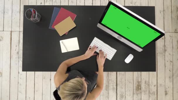 Giovane donna che lavora alla scrivania del suo ufficio con il computer. Visualizzazione finto schermo verde . — Video Stock