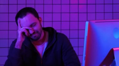 İşlemek için hacker sakallı programcı için program bekliyor. Monitör sonucu hakkında mutlu bakarak yorgun programcı.