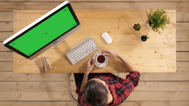 Casual vrouw koffie drinken in moderne kantoorruimte Infront van de computer. Groen scherm mock-up display. — Stockvideo