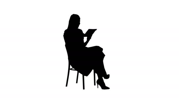 Sylwetka Śmieszne ładna młoda kobieta w różowej sukience siedzi na krześle i za pomocą tabletu. — Wideo stockowe