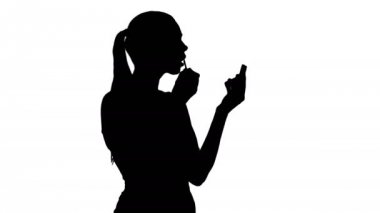 Güzel kadın siluet, onun dudaklarına ruj aynaya bakıyorum pembe boya.