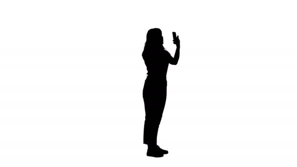Silhouette Όμορφη νεαρή γυναίκα εφαρμογή μάσκαρα κοιτάζοντας το τηλέφωνό της. — Αρχείο Βίντεο