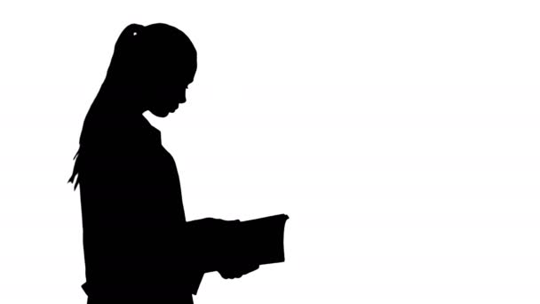 Silhouet aantrekkelijke geneeskunde student of arts met notebook wandelen en lezen. — Stockvideo