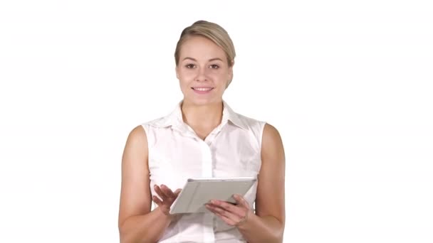 Νεαρή χαμογελαστή επιχειρηματίας με tablet υπολογιστή γυρίζοντας σελίδες και κοιτάζοντας στην κάμερα σε λευκό φόντο. — Αρχείο Βίντεο