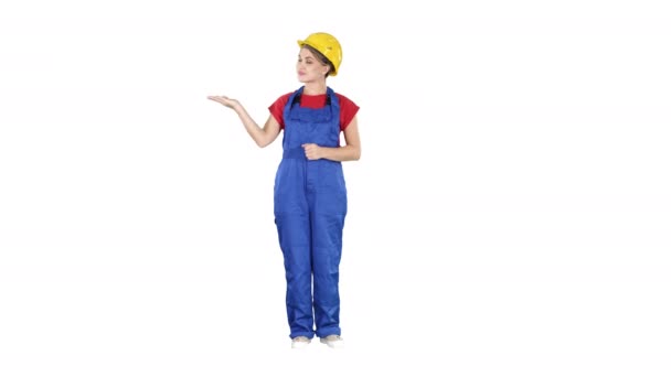 Mature engineer woman presenting a product pointing to side on white background. — Stock Video