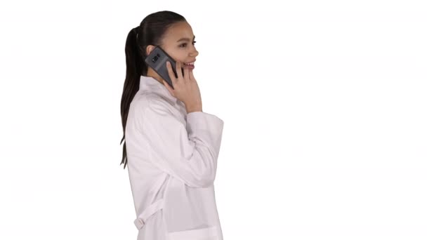 Kobieta Dr uśmiecha się podczas rozmowy telefonicznej, spacerując po białym tle. — Wideo stockowe