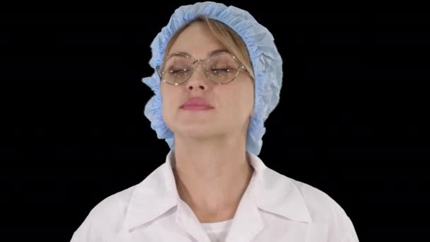 Woman doctor in glasses and hat walking and looking around, Alpha Channel — Stock Video