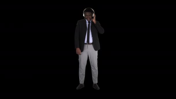 Jóképű afro-amerikai üzletember fülhallgatóban zenét hallgat, Alpha Channel — Stock videók