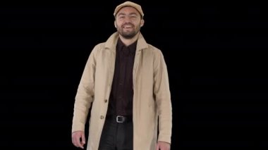 Palto giymiş gülümseyen adam kameraya bakıyor ve yürüyor, Alfa Kanalı.