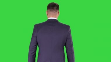 Yeşil ekranda, chroma key 'de yürüyen emin işadamı.