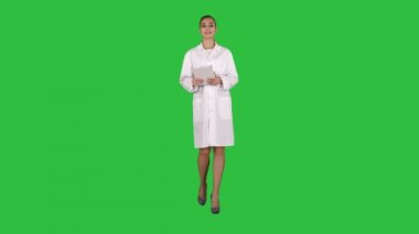 Mutlu kadın doktor kullanarak tablet bilgisayar üzerinde bir yeşil ekran üzerinde sayfaları dönüm, Chroma anahtar.