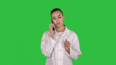 Emin kadın doktor, sağlık profesyonel bir yeşil ekranda hasta ile telefonda konuşan, Chroma anahtar.