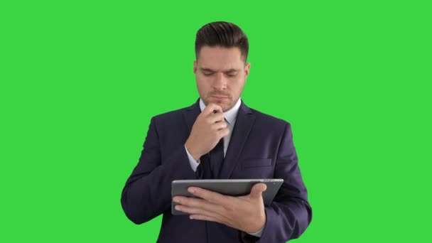 タブレットを見て、緑の画面で考えている若いビジネスマン、クロマ・キー. — ストック動画