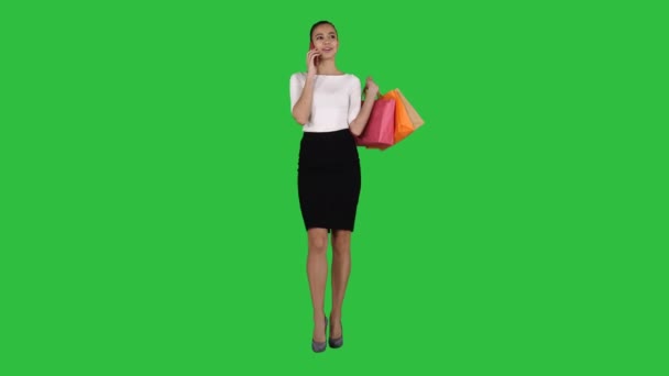Vrouw met tassen praten aan de telefoon op een groen scherm, Chromakey winkelen. — Stockvideo