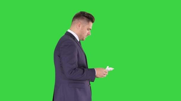 El hombre rico cuenta el dinero caminando en una pantalla verde, Chroma Key . — Vídeos de Stock