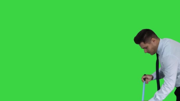 グリーンスクリーンで床を掃いている公式 clother の男、クロマ・キー. — ストック動画