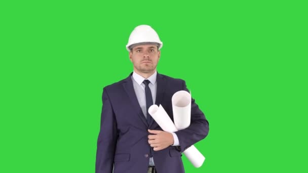 Мужчина-архитектор в костюме и в каске ходит с чертежами и портфелем на зеленом экране, Chroma Key . — стоковое видео