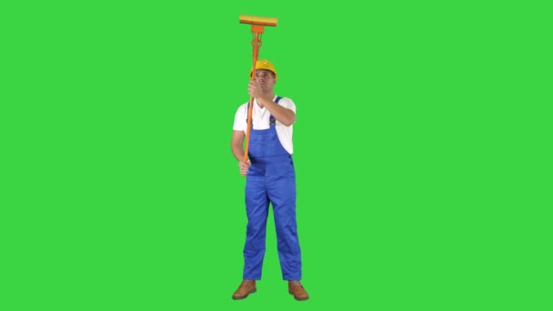 Smiling mid adult worker cleaning window with squeegee and smiling to camera on a Green Screen, Chroma Key. — Stock Video