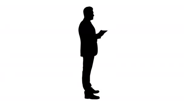 Silhouette Joven hombre de negocios tocando la tableta digital y comprobando el objeto frente a él . — Vídeos de Stock