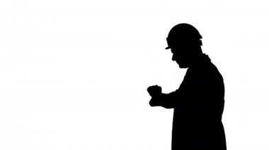 Mimarın siluet portresi. Şapka takmış, saate geç kalmış gibi bakıyor..