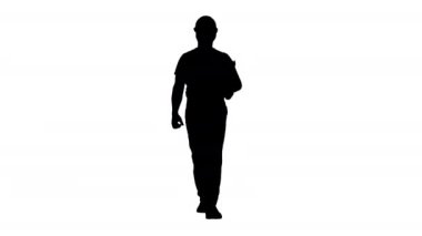 Silhouette müfettişi mühendis adam yürürken etrafında bakıyor.