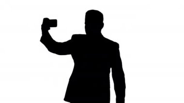 Yürüyüş yaparken takım elbise bir selfie alarak Silhouette yakışıklı adam.