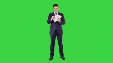 Yeşil Ekranda gülümseyen euro banknotgösteren iş adamı, Chroma Key.