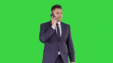 Takım elbiseli başarılı adam telefonda konuşuyor ve Yeşil Ekranda yürüyor, Chroma Key.