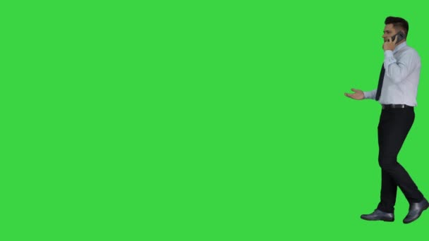 Homem maduro falando no celular andando dentro e fora do quadro em uma tela verde, Chroma chave . — Vídeo de Stock