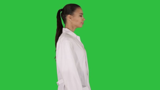 Ärztin Kosmetikerin im weißen Gewand läuft auf einem grünen Bildschirm, Chroma-Schlüssel. — Stockvideo