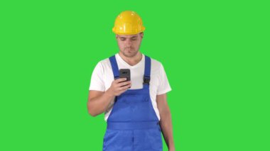 Fabrika işçisi çalışan Yeşil Ekranda akıllı telefonda mesajlaşma sohbet, Chroma Key.
