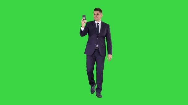 Giovane uomo d'affari che utilizza lo smartphone per videocall al partner commerciale mentre si cammina su uno schermo verde, Chroma Key . — Video Stock