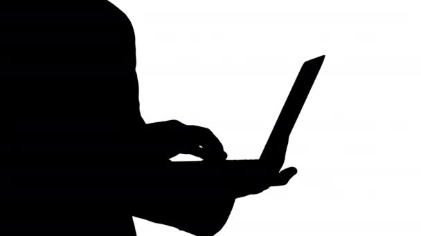 Silhouette Homme d'affaires debout et utilisant un ordinateur portable. — Video