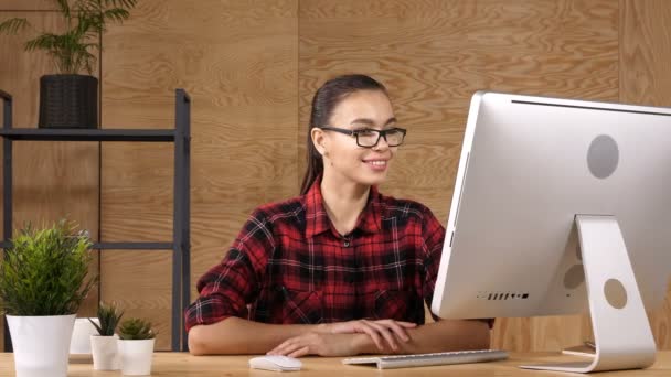 Молодая удивительная женщина, сидящая перед компьютером — стоковое видео