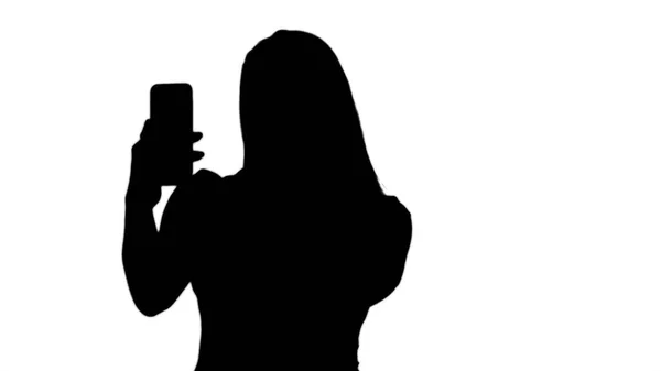 剪影快乐的女人用手机拍自拍照片. — 图库照片