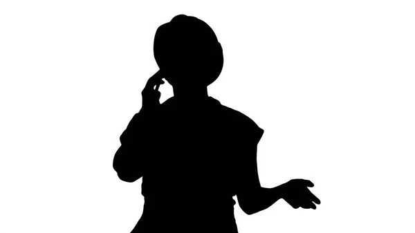 Sylwetka Młoda pracownica rozmawia przez telefon podczas spaceru. — Zdjęcie stockowe