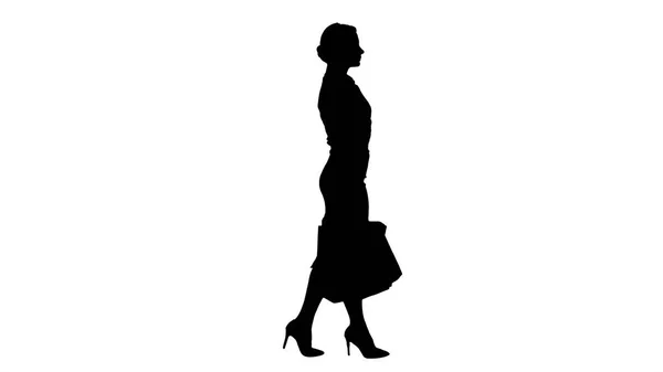 Silhouette Happy donna piena lunghezza che tiene borse della spesa di carta in ogni mano e camminare. — Foto Stock