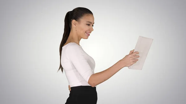 Szczęśliwa kobieta wykonująca rozmowę wideo z tabletem na gradientowym tle. — Zdjęcie stockowe