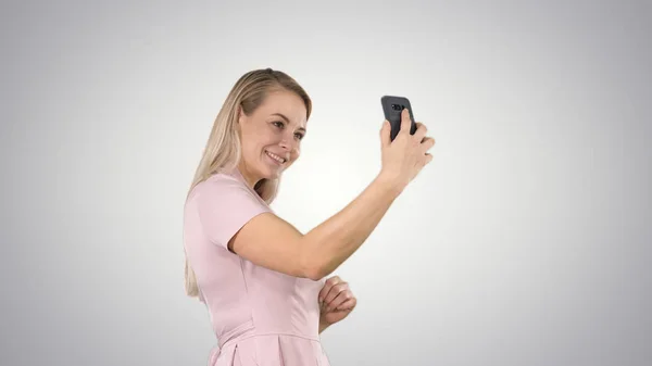 Mulher bonita fazendo selfies no fundo gradiente. — Fotografia de Stock