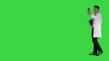 Erkek doktor yeşil ekranda hastasıyla konuşurken görüntülü görüşme yapıyor, Chroma Key.