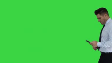 Adam telefon bakıyor yürüyüş ve yeşil ekran, Chroma anahtar kazanmak jest yapma.