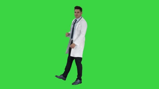 Médico feliz mostrando algo perto dele e sorrindo em uma tela verde, Chroma Key . — Vídeo de Stock