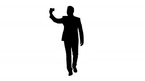 Silhouette Bello uomo in giacca e cravatta che si fa un selfie mentre cammina . — Video Stock